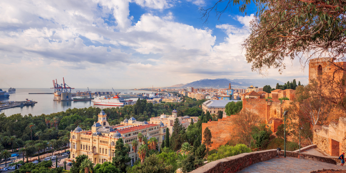Vista panorámica de la ciudad y el puerto de Málaga con la Alcazaba, edificios históricos y montañas al fondo, Andalucía, España