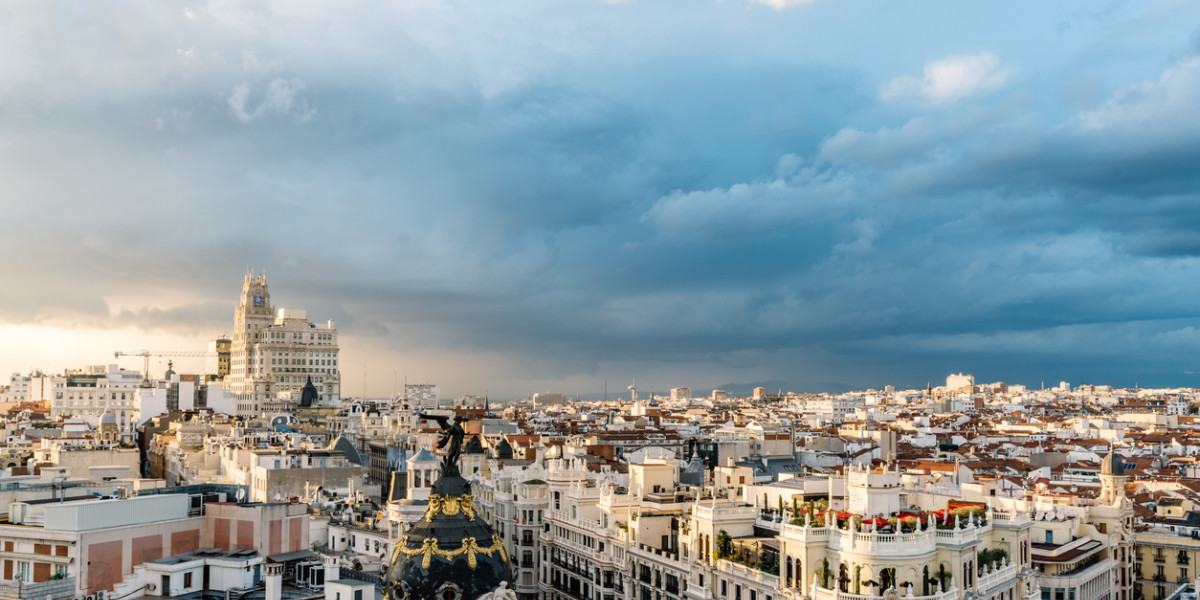 ista panorámica del centro de Madrid con el icónico Edificio Metrópolis y la Gran Vía al atardecer.
