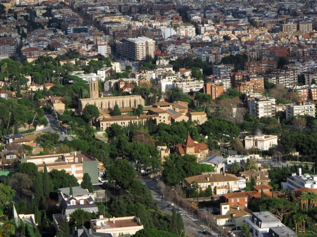 Vista aérea de la zona alta de Barcelona con elegantes residencias rodeadas de vegetación y edificios históricos.