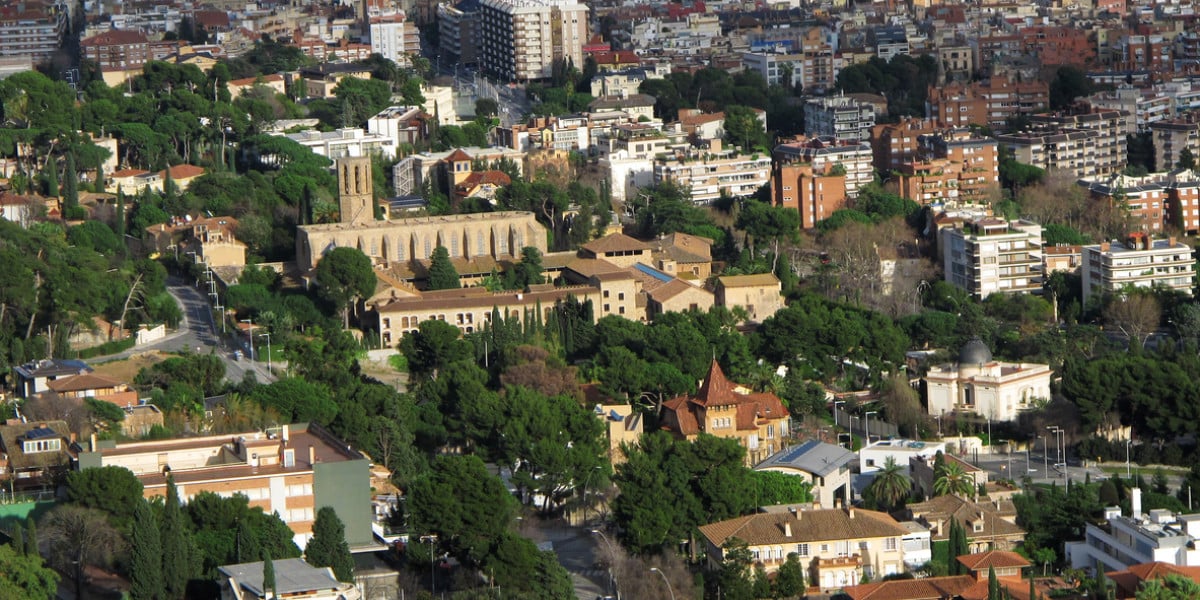 Vista aérea de la zona alta de Barcelona con elegantes residencias rodeadas de vegetación y edificios históricos.